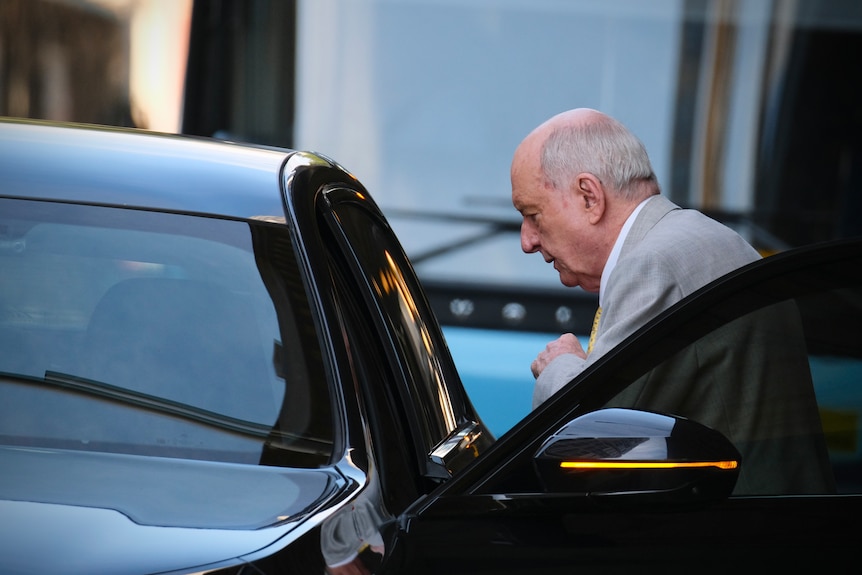 Alan Jones exiting a black vehicle.