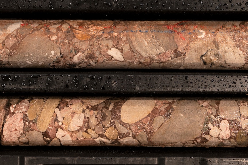 Two long cylinders are actually rock cores from deep underground, made up of rocks of all shapes, textures and sizes.