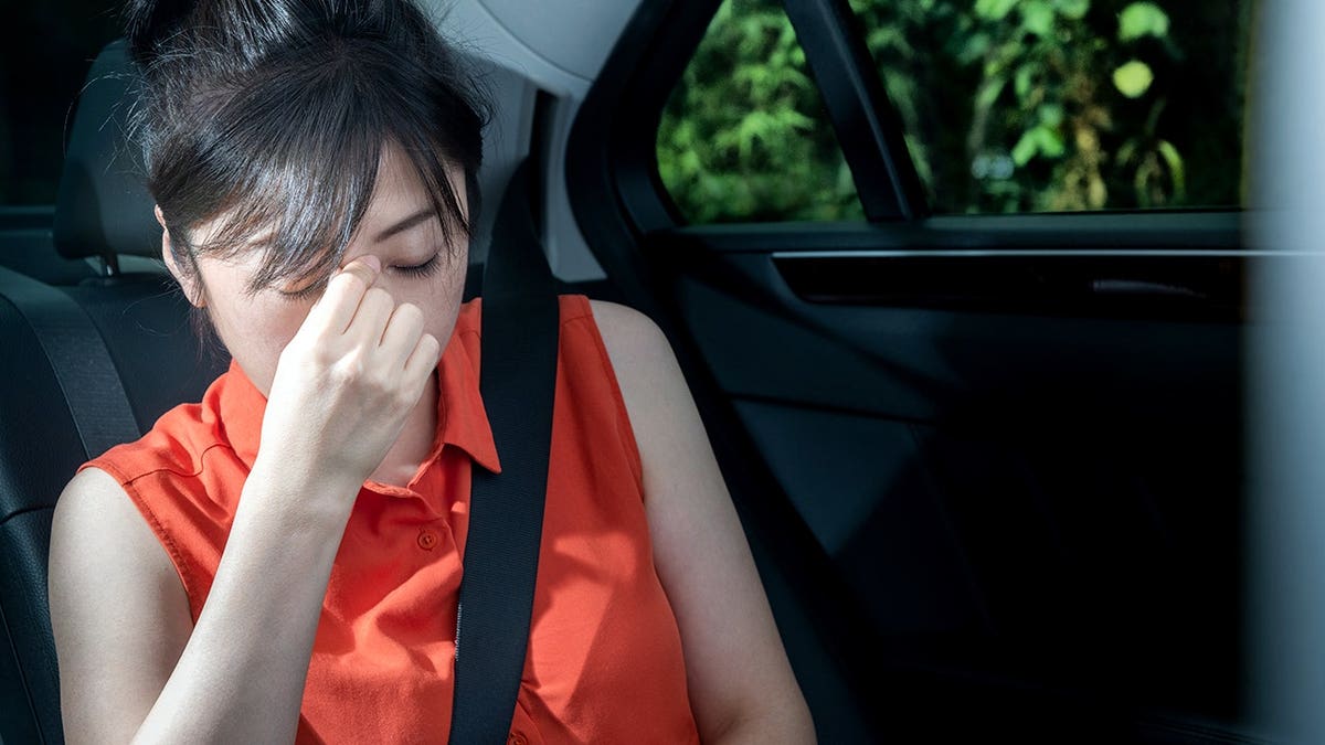 A woman is carsick.