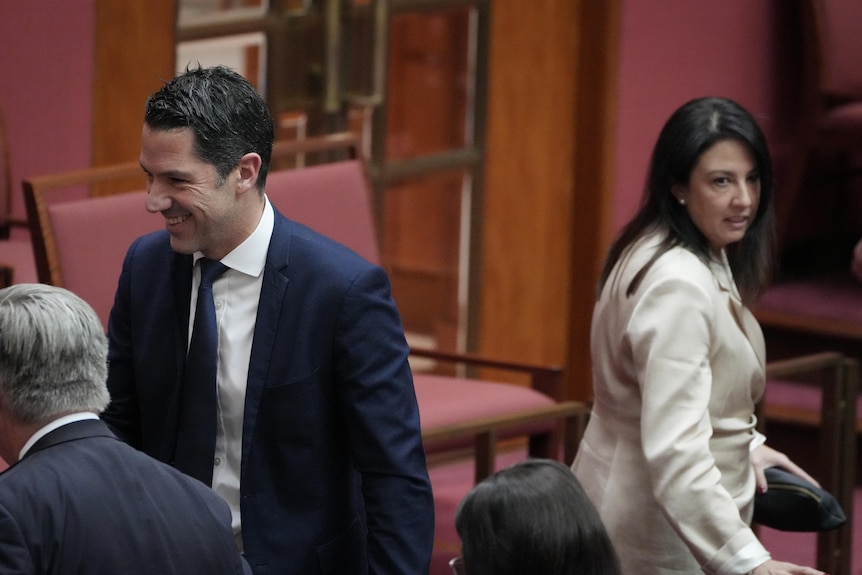 Senator Alex Antic walking to the left of screen while Senator Leah Blyth walks to the right