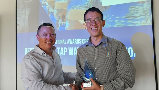 Ryan Walker of IXOM presents the trophy to Seungchan Bang, maintenance planner for Isaac Regional Council.