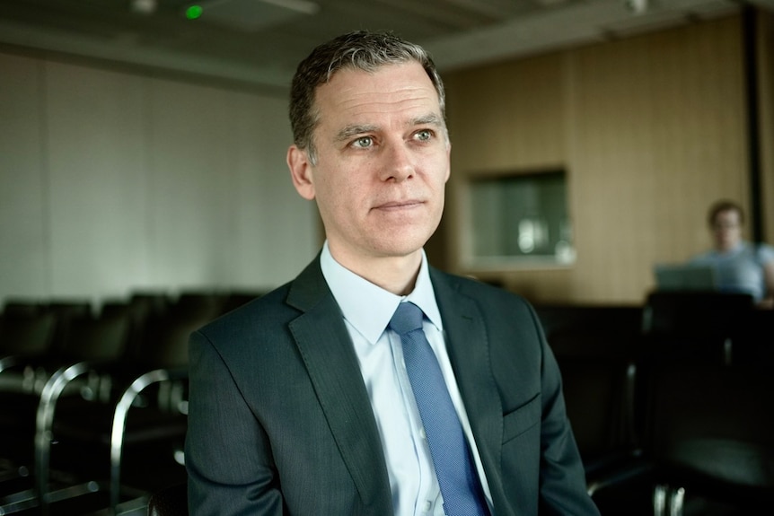 Man in suit sits in boardroom