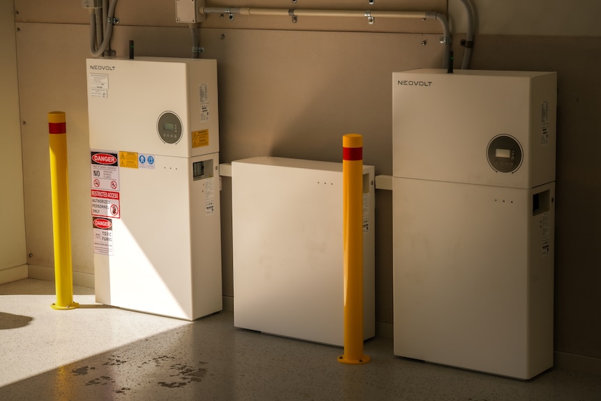 A solar battery and inverter setup against a wall.