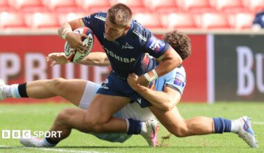 Joe Carpenter scores his third try for Sale despite being tackled by a Bath defender