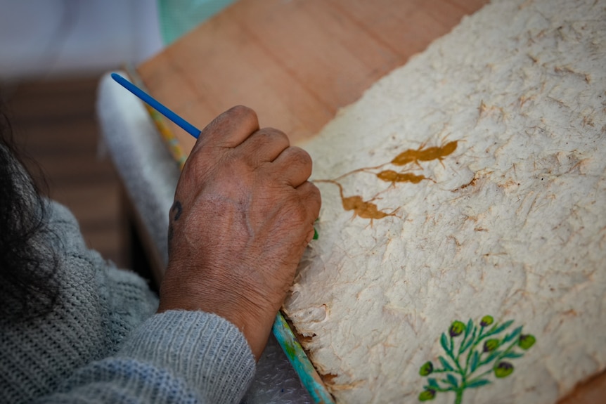 Carita Coultard paints one of her bush tucker paintings.