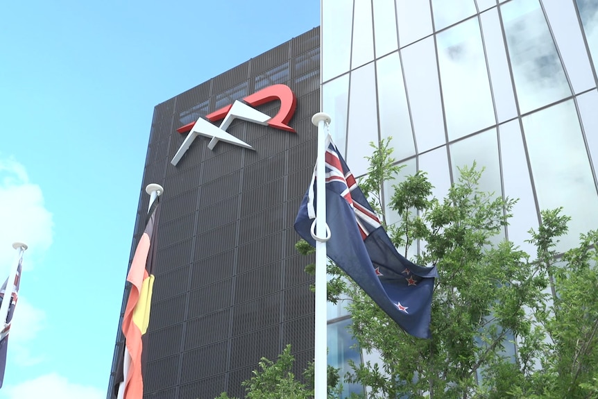A large building with flags out the front. 