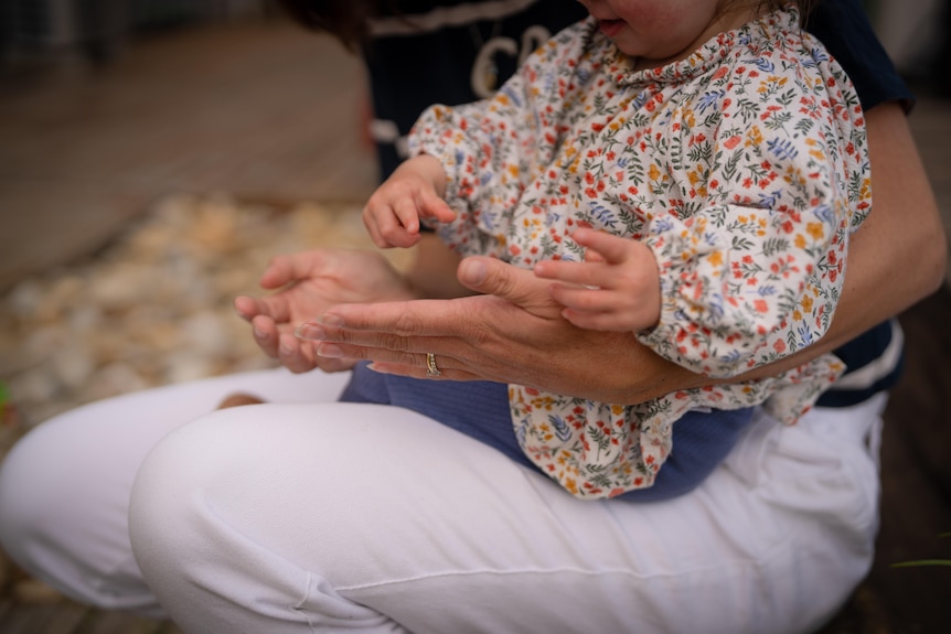 A parent and child with focus on hands.