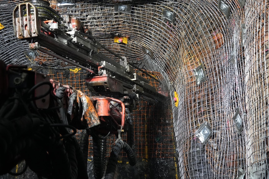 A drilling machine works at the bottom of a mine 