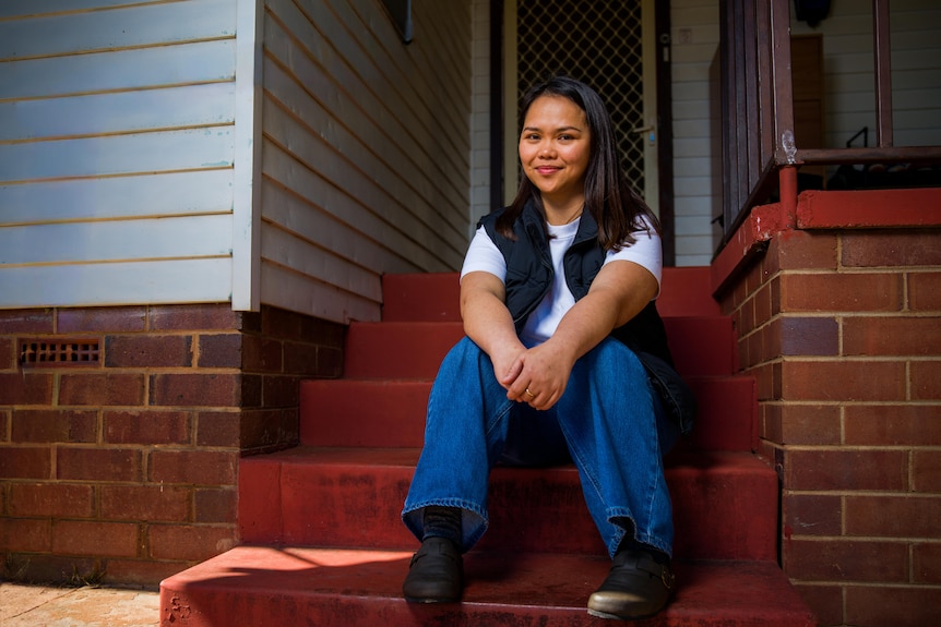 April sits by herself on the front step of her house in Coolamon.