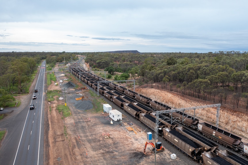 Aerial photo of a line of coal trains parallel to the highway near Bluff, Queensland, November 2021.
