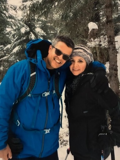 A man and a woman wearing clothes appropriate for snow smile at the camera. They are surrounded by snow.