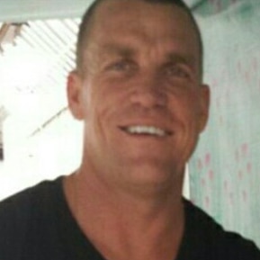 A Caucasian man in a black t-shirt smiles in a photo.
