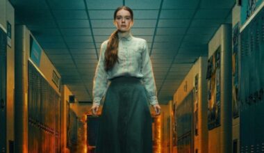 young girl in simple skirt and blouse standing in high school hallway as flames billow behind her