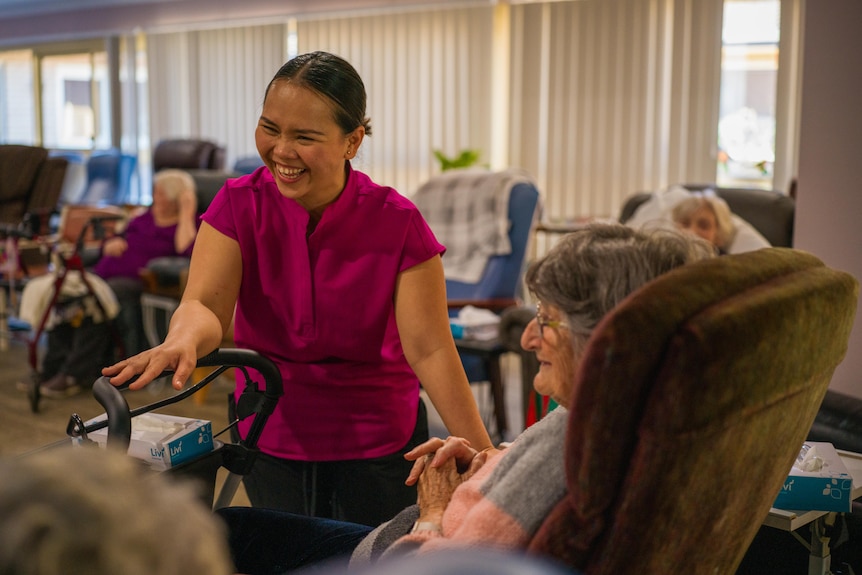 April Laguros stands smiling next to a resident in Allawah Lodge aged care facility