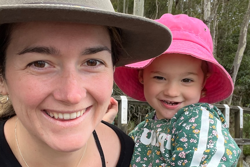 A woman and toddler smiling at the camera.