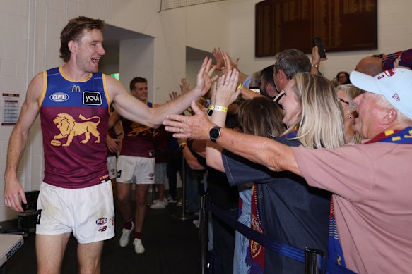 Overjoyed Brisbane Lions fans welcome Harris Andrews into the change rooms after the win over Hawthorn.