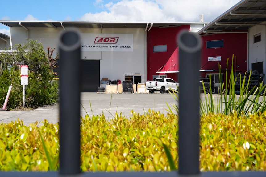 The AOR warehouse pictured through a fence