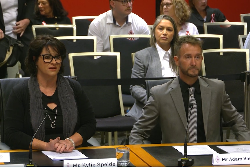 Kylie Spelde and Adam Vaughan sit at a table speaking to the inquiry