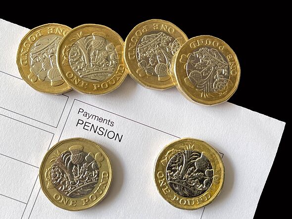 One pound coins and a pension payment slip