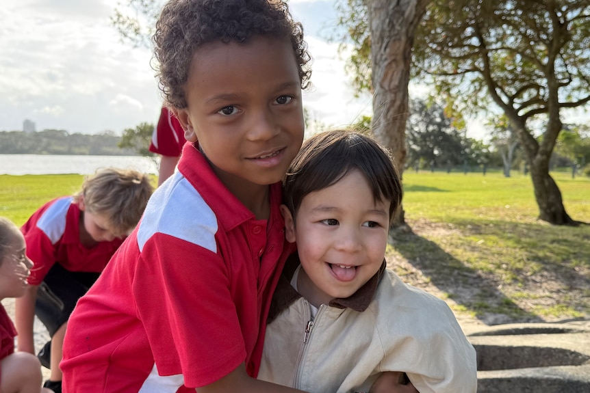 Boy in red school shirt with smaller brother