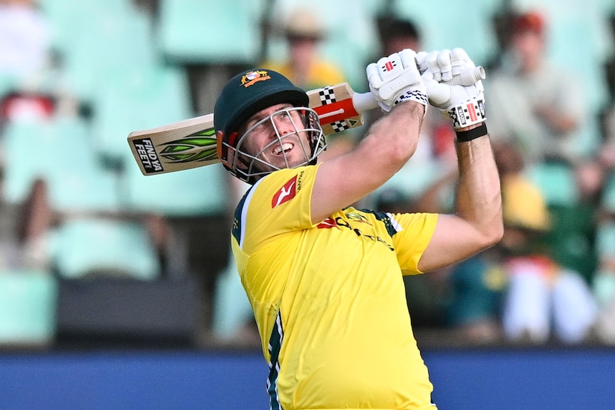 Mitchell Marsh swings a bat and watches the ball