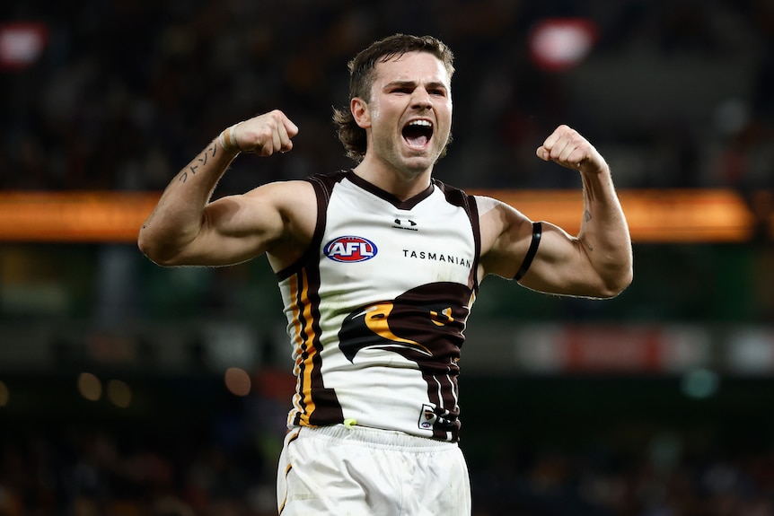 Nick Watson of the Hawks celebrates a goal, flexing his arm muscles
