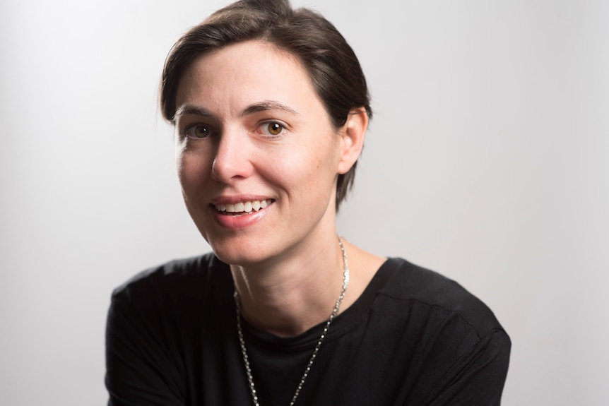 A headshot of a woman with short, dark hair