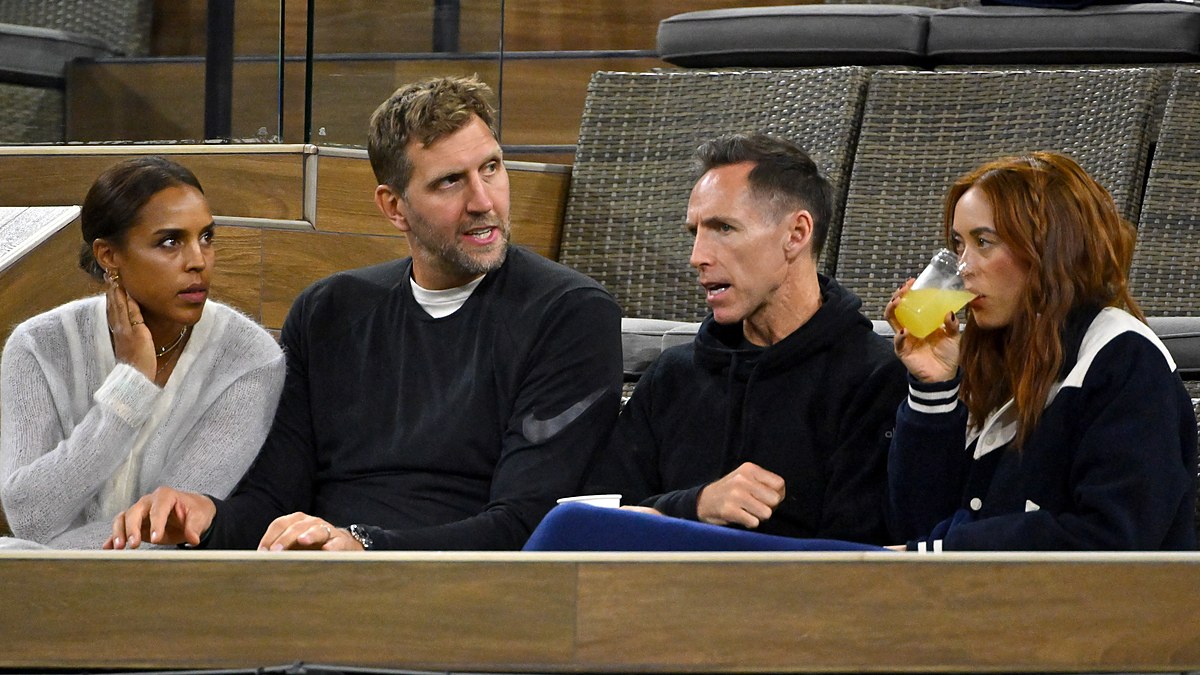 Former Dallas Mavericks teammates Dirk Nowitzki and Steve Nash talk while watching a tennis match from their seats.