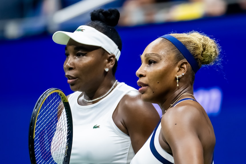 Venus and Serena Williams standing on the tennis court