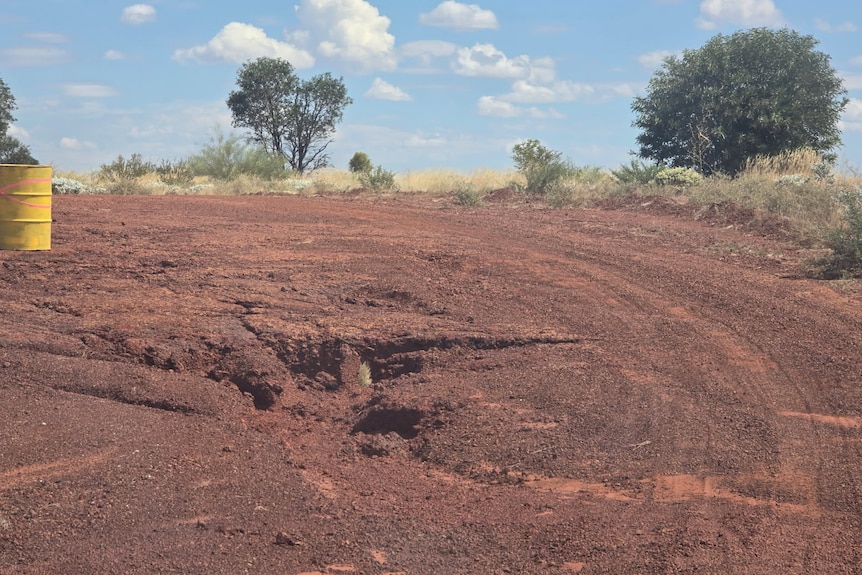 A weather damaged unsealed road.