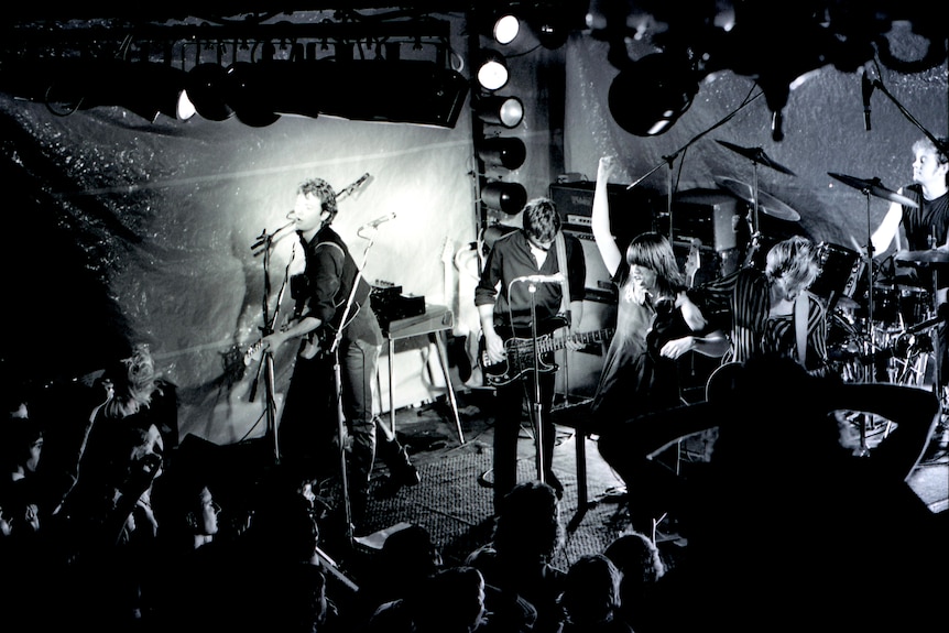 Divinyls on stage in a blurry black and white photo.