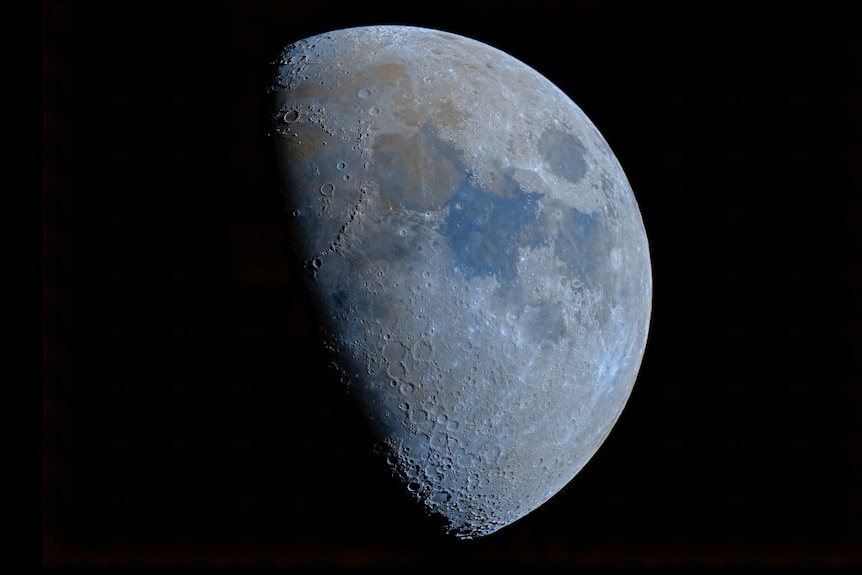 A photograph of the Moon half-obscured by shadows.