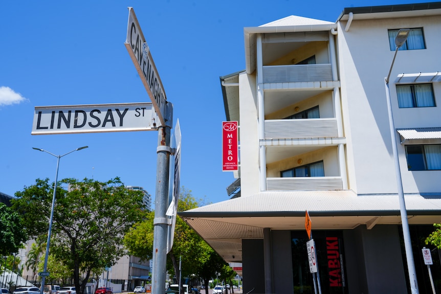 A street sign outside the Metro Hotel on Cavenagh Street with the hotel's sign in the background.