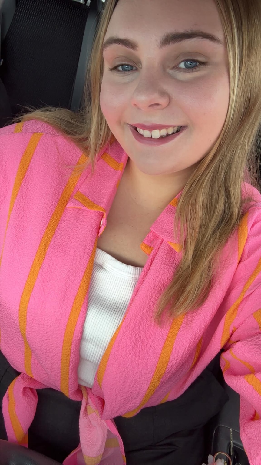 A young blonde woman smiles at the camera.