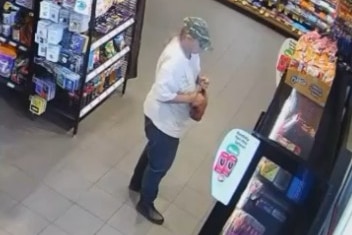 CCTV of a woman in a cap at the counter of a shop buying food.
