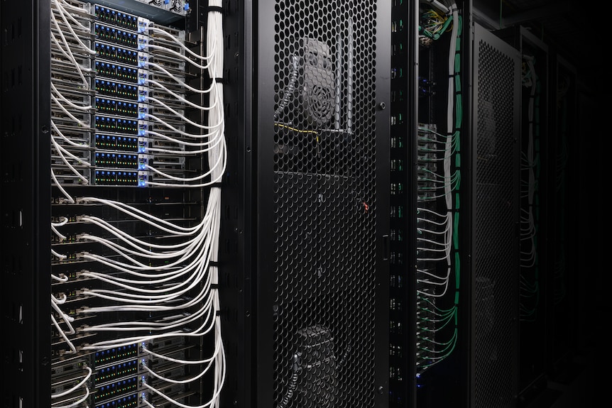 Close-up of NVIDIA AI server racks filled with computing equipment, cables and cooling systems.