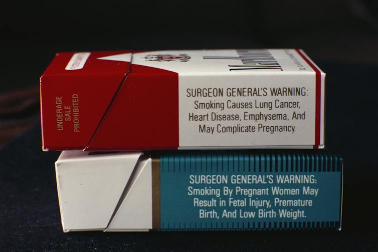 Two packs of cigarettes showing Surgeon General's warning labels about the harms of smoking.