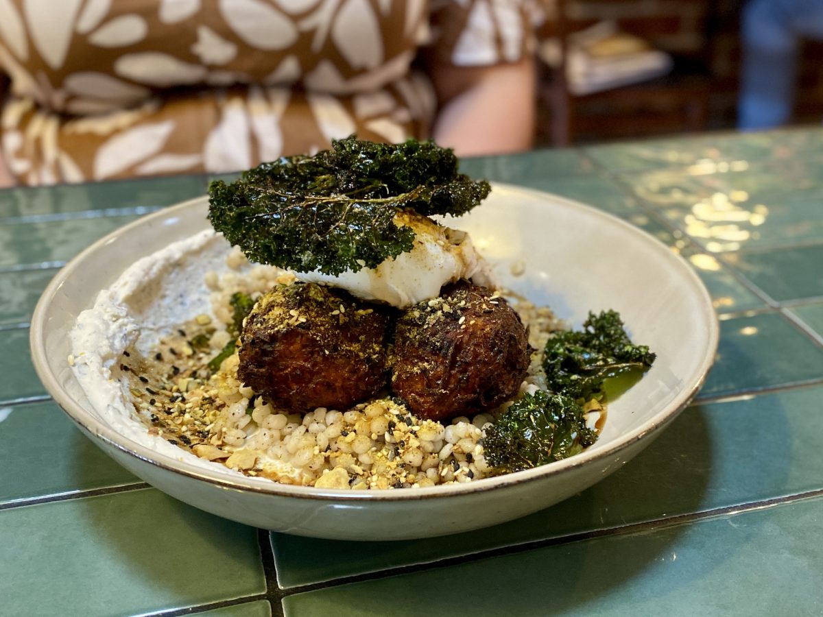 a dish of fritters topped with piece of crispy kale.