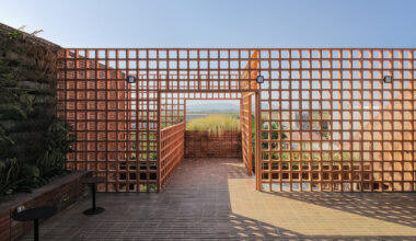 stone and terracotta layer across three-story gathering space in indonesia