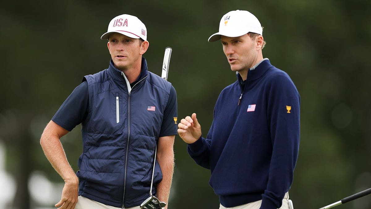 Jacob Bridgeman and Russell Henley line up a putt on the 17th green.