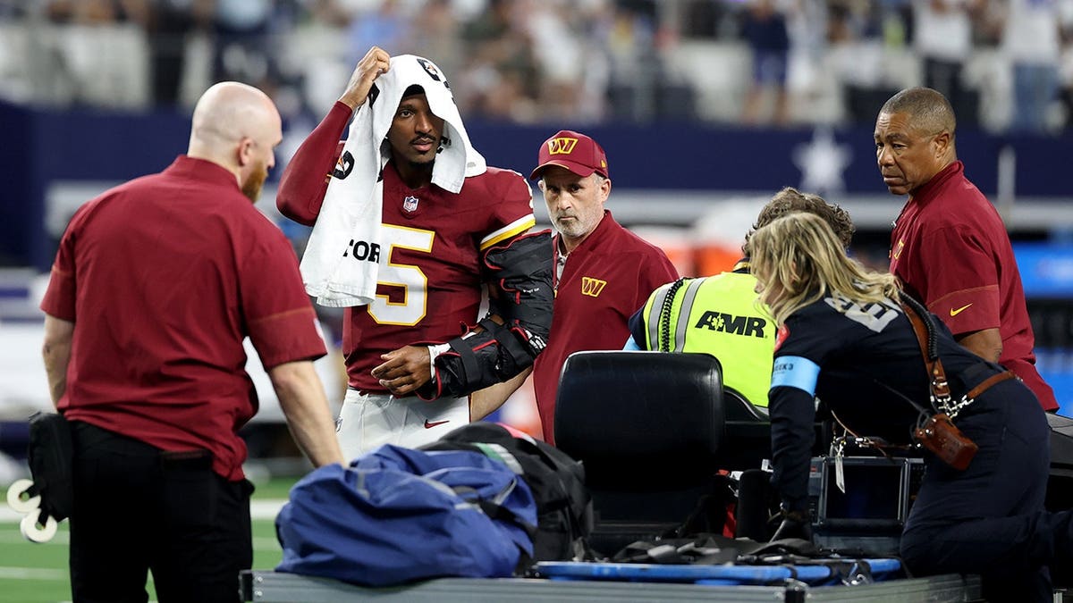 Jayden Daniels looks on before being carted off the field.