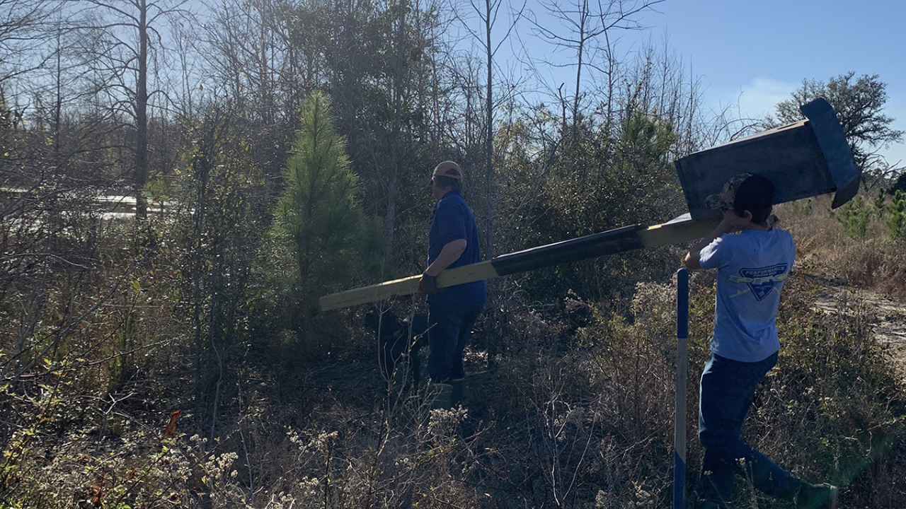 JOHN CARL TILGHMAN (RIGHT) ASSISTS HIS FATHER AS THEY PUT OUT WOOD DUCK BOXES FOR WOOD DUCKS TO NEST IN/Image: John Carl Tilghman JOHN CARL TILGHMAN (RIGHT) ASSISTS HIS FATHER AS THEY PUT OUT WOOD DUCK BOXES FOR WOOD DUCKS TO NEST IN/Image: John Carl Tilghman<br>