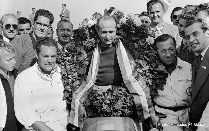 Dutch Grand Prix in Zandvoort on 19 June 1955. Winner Juan Manuel Fangio (in a Mercedes-Benz W 196 R with start number 8) with laurel wreath and mechanics Erwin Grupp and Hermann Eger (left).