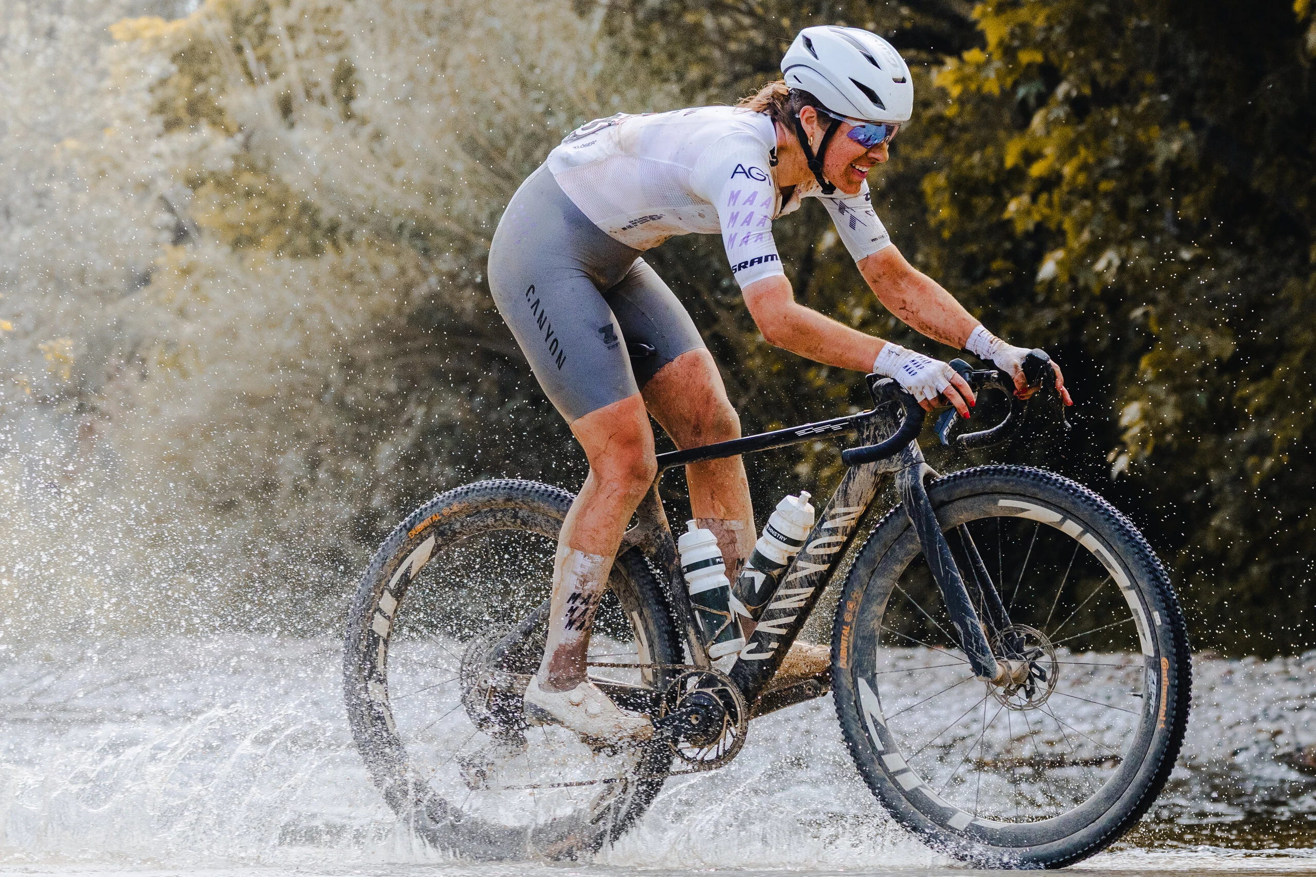 A gravel racer riding a Canyon Grail through a stream