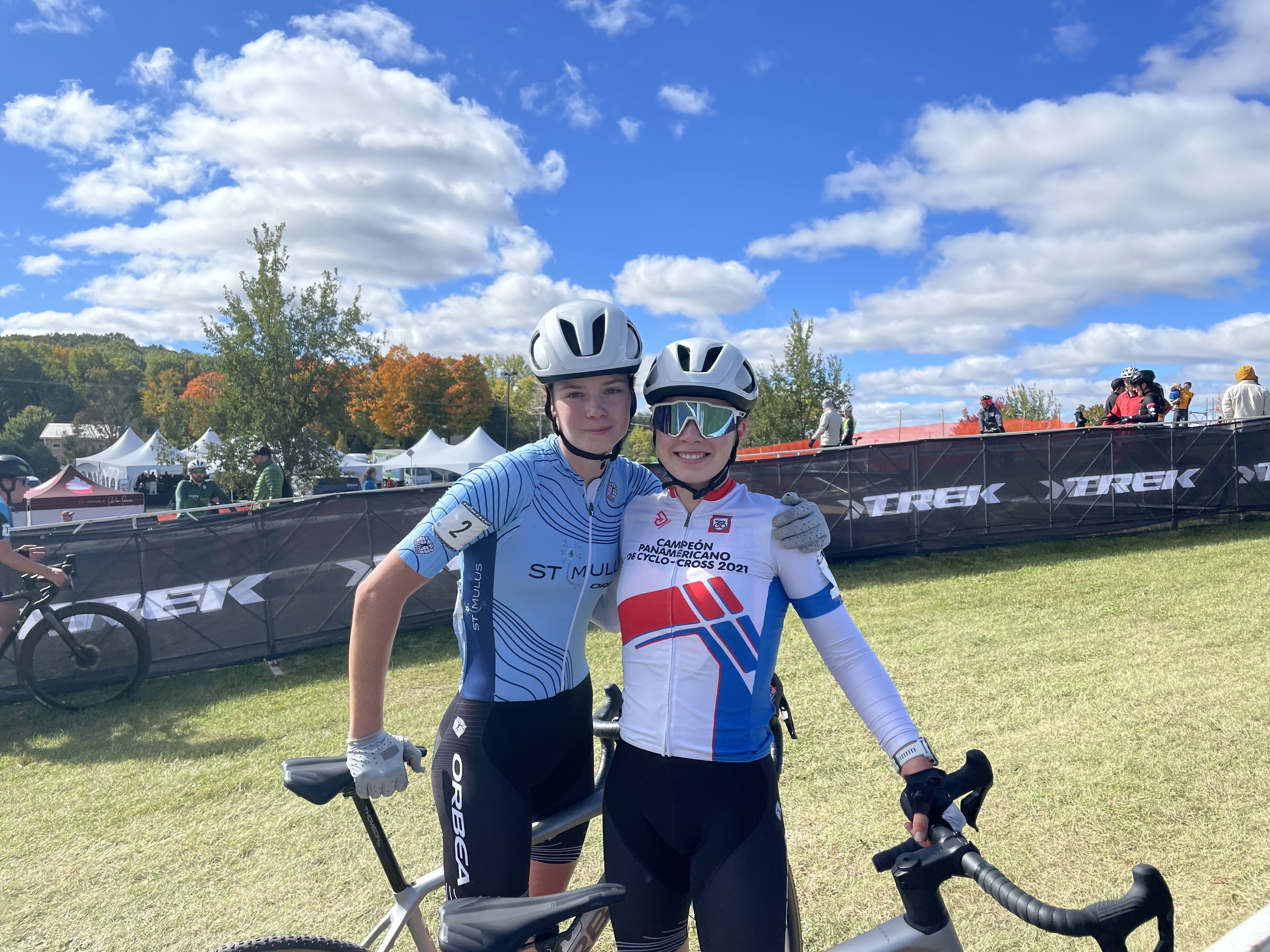 Isabella Holmgren (left) stands next to sister Ava Holmgren, wearing the Pan-American Cyclo-cross junior champions jersey