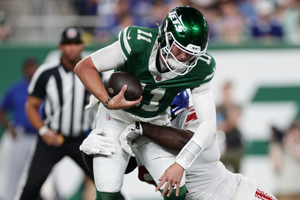 New York Jets quarterback Bailey Zappe (11) is tackled by New York Giants defensive lineman Bobby Jamison-Travis (97) during a preseason NFL game.