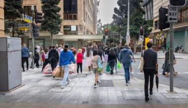 A group of people are walking across the street.