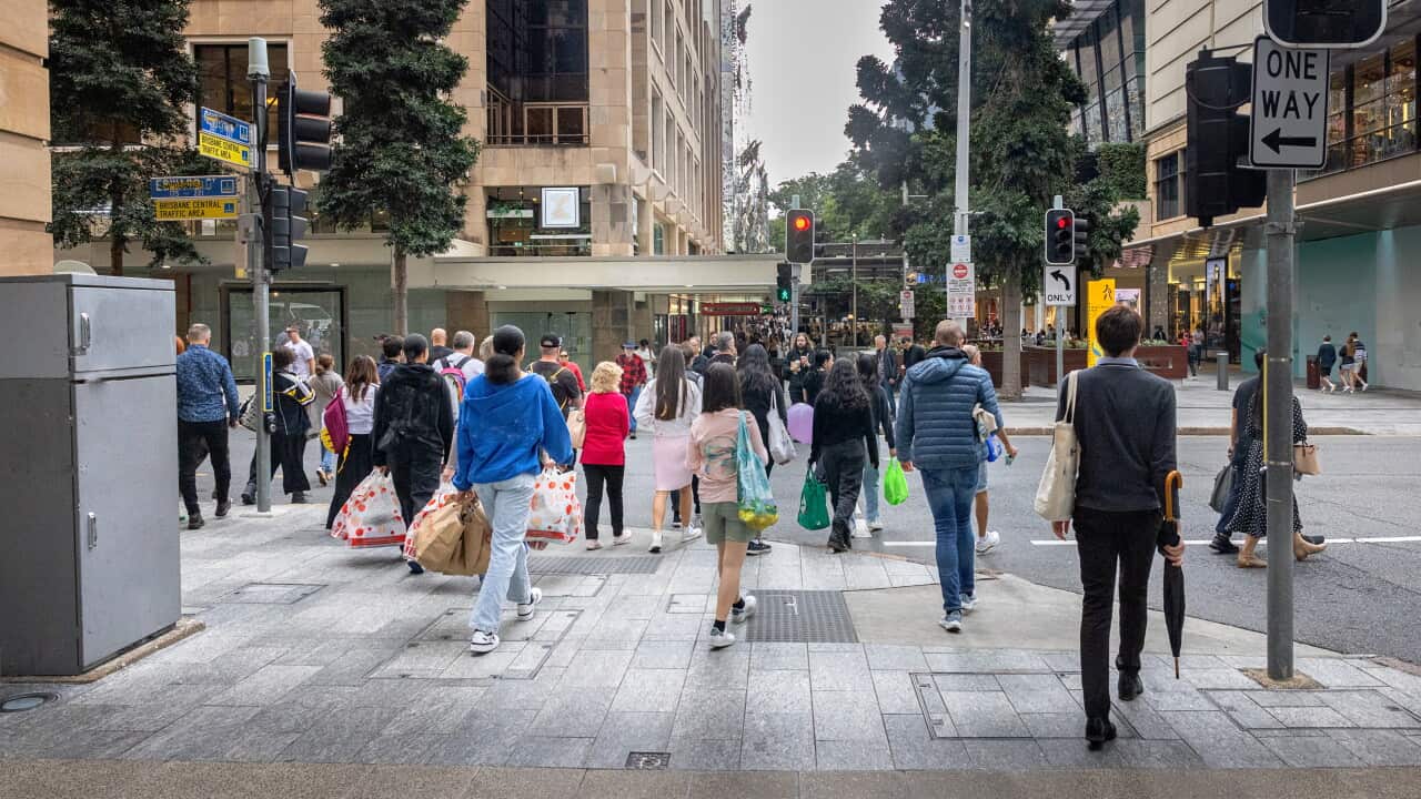A group of people are walking across the street.