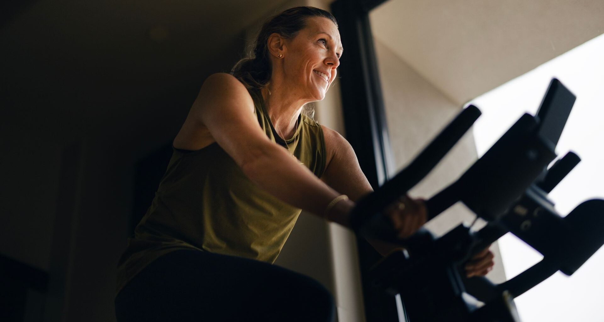 Woman doing cycling workout, smiling