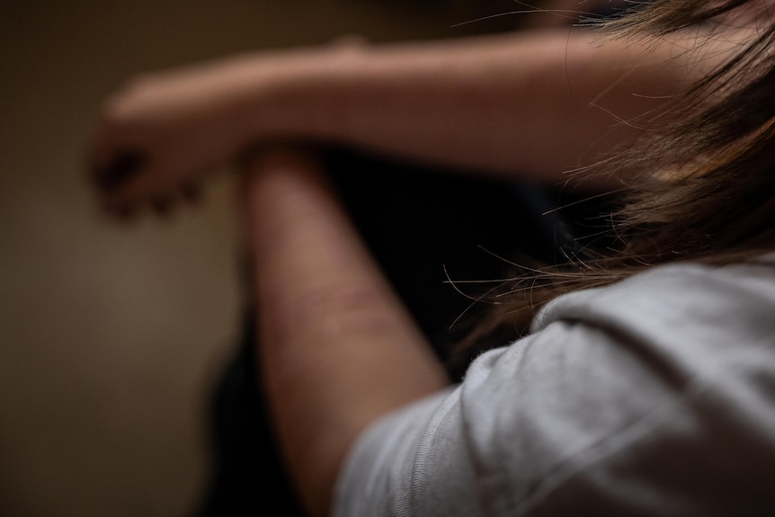 A teenage girls arms, blurred from scarring.
